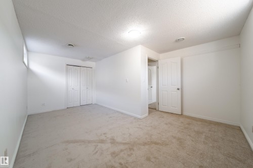 Spacious room featuring light-colored carpet, white walls, and a white bi-fold closet door - 3518 78 Street, Edmonton, AB - Indoor Photo Showing Other Room