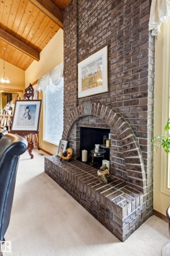 Floor-to-ceiling brick fireplace with an arched firebox opening and an extended hearth - 11707 29 Avenue Nw, Edmonton, AB - Indoor Photo Showing Other Room With Fireplace
