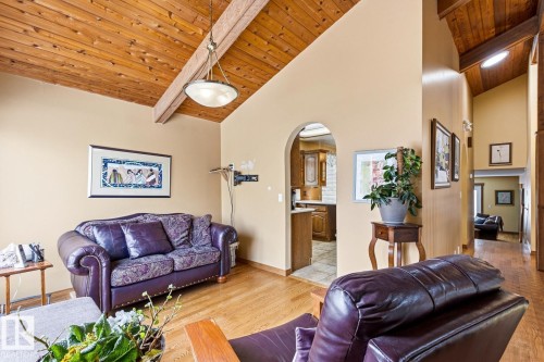 Vaulted wood-finish ceilings with exposed beams, wood-finish flooring, and arched doorways - 11707 29 Avenue Nw, Edmonton, AB - Indoor Photo Showing Living Room