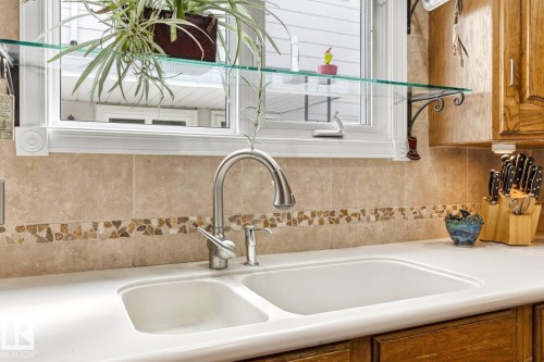 Dual-basin white sink with a gooseneck faucet - 11707 29 Avenue Nw, Edmonton, AB - Indoor Photo Showing Kitchen With Double Sink