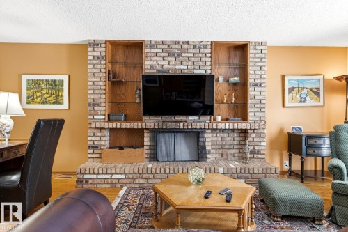 Brick fireplace with integrated wood shelving, a raised hearth, and a built-in media niche - 11707 29 Avenue Nw, Edmonton, AB - Indoor Photo Showing Living Room With Fireplace