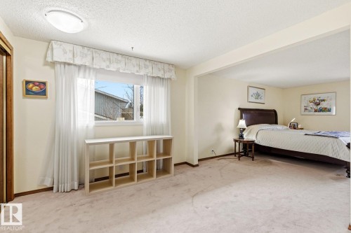 Carpeted interior space with a built-in shelving unit, a window, and a recessed sleeping area - 11707 29 Avenue Nw, Edmonton, AB - Indoor Photo Showing Bedroom