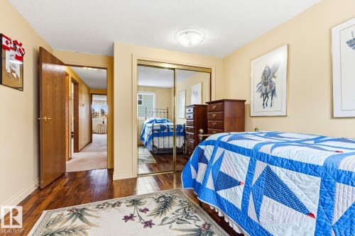 Bedroom featuring wood-finish flooring, a mirrored closet, and a neutral color palette - 11707 29 Avenue Nw, Edmonton, AB - Indoor Photo Showing Bedroom