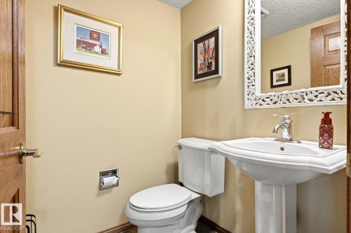Pedestal sink with chrome faucet, complemented by a white carved mirror frame - 11707 29 Avenue Nw, Edmonton, AB - Indoor Photo Showing Bathroom