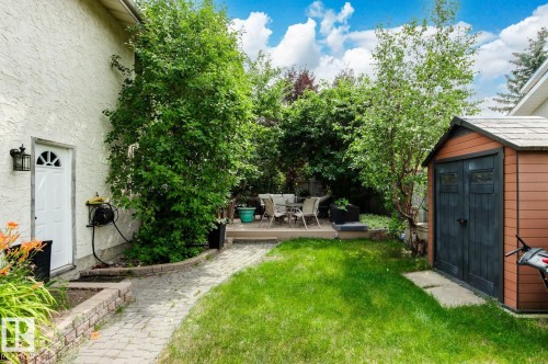 Expansive backyard featuring a green lawn, paver stone pathway, and mature trees - 11707 29 Avenue Nw, Edmonton, AB - Outdoor