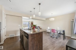 Kitchen featuring a center island with a granite countertop, a stainless steel sink, and a dishwasher - 