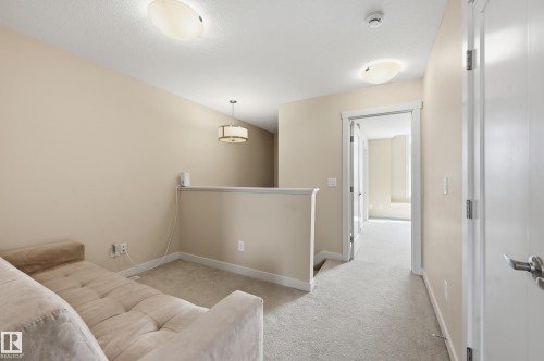 This property features light-colored carpet, neutral walls, and white trim throughout - 701 Allard Boulevard, Edmonton, AB - Indoor Photo Showing Other Room