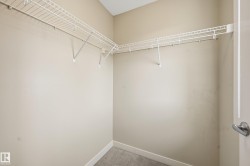 The property features a walk-in closet with wire shelving and gray carpet flooring - 