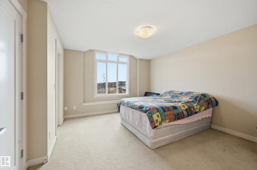 This room features a window with a wide sill, light-colored carpeting, and neutral-toned walls - 701 Allard Boulevard, Edmonton, AB - Indoor Photo Showing Bedroom
