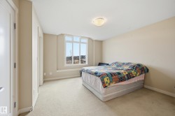 This room features a window with a wide sill, light-colored carpeting, and neutral-toned walls - 