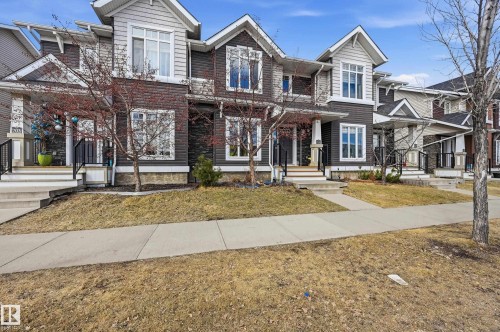 The property features a multi-level facade with light and dark siding, complemented by white window frames - 701 Allard Boulevard, Edmonton, AB - Outdoor With Facade