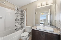 Bathroom with a shower and bathtub combination, a vanity with a granite countertop, and a large mirror - 