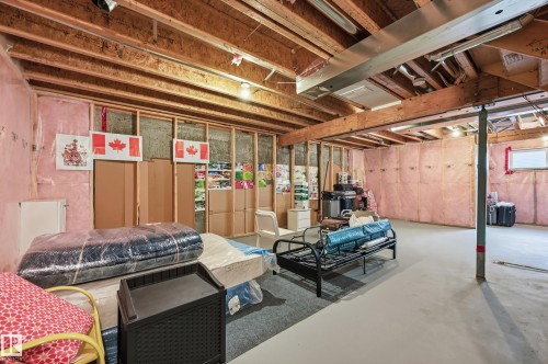 The unfinished basement features exposed wooden joists and framing, with insulation visible along the walls - 701 Allard Boulevard, Edmonton, AB - Indoor Photo Showing Basement