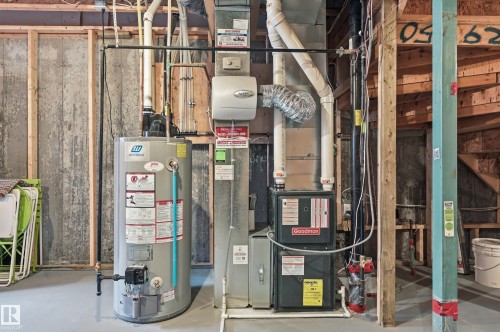 This utility space features a water heater and a forced air furnace, providing essential home systems - 701 Allard Boulevard, Edmonton, AB - Indoor Photo Showing Basement