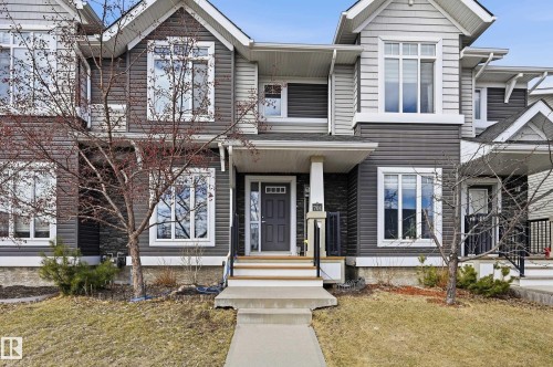 The property features a dark gray and light gray exterior siding, with white trim around the windows and eaves - 701 Allard Boulevard, Edmonton, AB - Outdoor With Facade