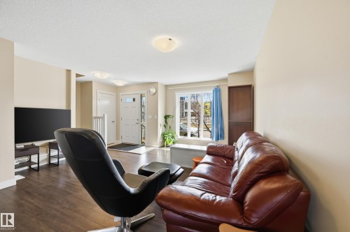 The living area features hard surface flooring and a large window, providing natural light - 701 Allard Boulevard, Edmonton, AB - Indoor