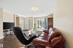 The living area features hard surface flooring and a large window, providing natural light - 