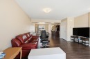 The property features light-colored walls and dark wood flooring - 701 Allard Boulevard, Edmonton, AB  - Indoor Photo Showing Living Room 