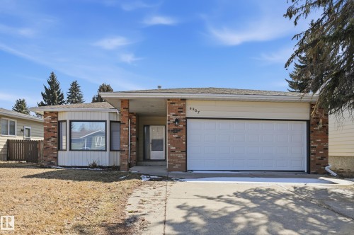 The property features a brick and siding exterior with a prominent garage and a bay window - 6907 19 Avenue, Edmonton, AB - Outdoor