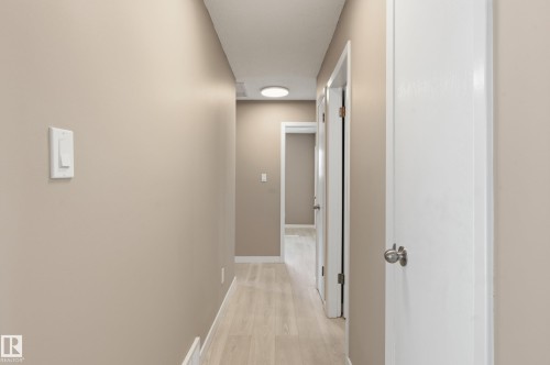 The property features a hallway with light-toned flooring, neutral wall paint, and white trim - 6907 19 Avenue, Edmonton, AB - Indoor Photo Showing Other Room