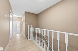 The entry features light-toned flooring and a white front door - 