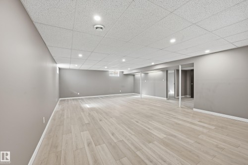 Spacious room with light-toned plank flooring, neutral wall paint, and recessed lighting - 6907 19 Avenue, Edmonton, AB - Indoor