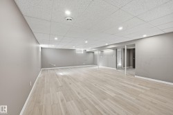 Spacious room with light-toned plank flooring, neutral wall paint, and recessed lighting - 