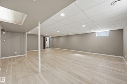 Spacious finished basement featuring light-colored flooring, recessed lighting, and a window - 