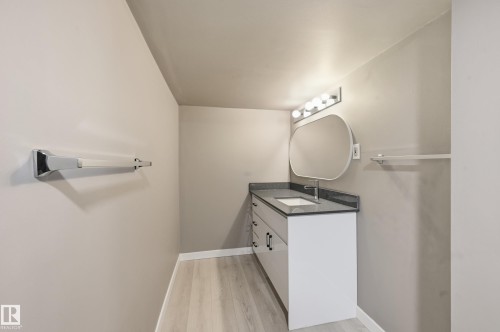 Bathroom with a contemporary vanity, an oval mirror, and light-colored flooring - 6907 19 Avenue, Edmonton, AB - Indoor Photo Showing Laundry Room
