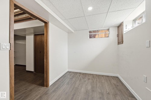 The property features wood-look flooring and white walls throughout - 6907 19 Avenue, Edmonton, AB - Indoor Photo Showing Other Room