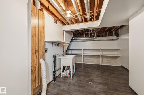 Utility room featuring a utility sink, open shelving, and exposed wooden ceiling beams - 6907 19 Avenue, Edmonton, AB - Indoor