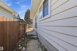 The property features light-colored horizontal siding and a window with white trim - 