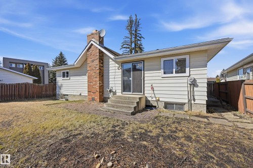 The property features a brick chimney, a patio area with steps, and a sliding glass door - 6907 19 Avenue, Edmonton, AB - Outdoor