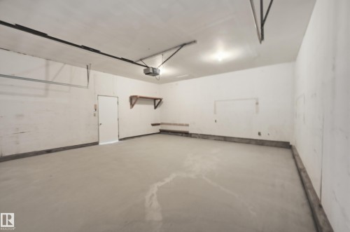 Spacious garage featuring concrete flooring, white walls, and overhead lighting - 6907 19 Avenue, Edmonton, AB - Indoor Photo Showing Garage