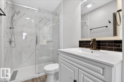 Contemporary bathroom featuring a spacious shower with sliding glass doors and white marble-look tile surround - 