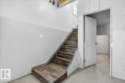 Wood-finish staircase with risers and treads, featuring a partial wall with light gray paint - 