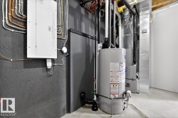 Utility area featuring a water heater, furnace, and electrical panel - 
