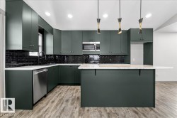 Contemporary kitchen featuring dark green cabinetry, a black subway tile backsplash, stainless steel appliances, and a central island with an extended countertop - 
