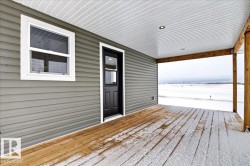Covered porch featuring wood-finish decking, light gray horizontal siding, and a white beadboard ceiling with recessed lighting - 