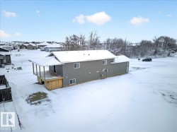 Gray siding exterior with multiple windows, a rear deck, and a covered porch - 