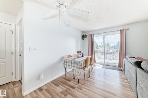 This inviting room features light-toned flooring, a ceiling fan, and a sliding glass door with balcony access - 317 7511 171 Street, Edmonton, AB - Indoor