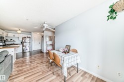 The bright living area features light wood-style flooring and a ceiling fan - 