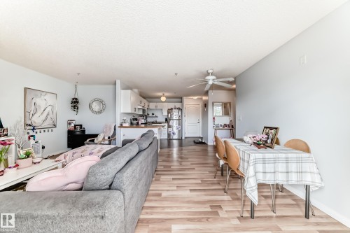 The open concept living area features light wood flooring and light-colored walls, creating a bright and airy atmosphere - 317 7511 171 Street, Edmonton, AB - Indoor