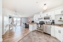 The property features an open concept kitchen and living area with a ceiling fan, light wood-style flooring, and a sliding glass door leading to a balcony - 317 7511 171 Street, Edmonton, AB  - Indoor Photo Showing Kitchen With Double Sink 