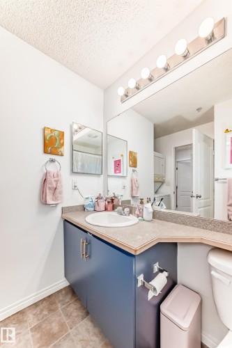 Bathroom featuring a vanity with a white sink, blue cabinetry, and a countertop - 317 7511 171 Street, Edmonton, AB - Indoor Photo Showing Bathroom