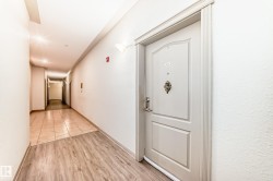 Entrance door featuring a decorative knocker and a light-colored finish, with wood-style flooring at the entryway - 