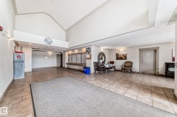 Spacious common area featuring tiled flooring, vaulted ceilings, and decorative wall sconces - 