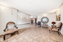 This welcoming common area features tiled flooring, wall sconces, and a decorative mirror - 