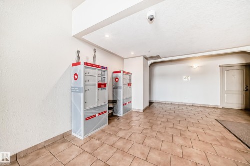 The property features an entryway with tiled flooring and white walls, leading to individual mailboxes - 317 7511 171 Street, Edmonton, AB - Indoor Photo Showing Other Room