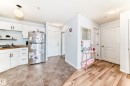 The property features a kitchen with white cabinetry, wooden countertops, and a stainless steel refrigerator - 317 7511 171 Street, Edmonton, AB  - Indoor Photo Showing Kitchen 
